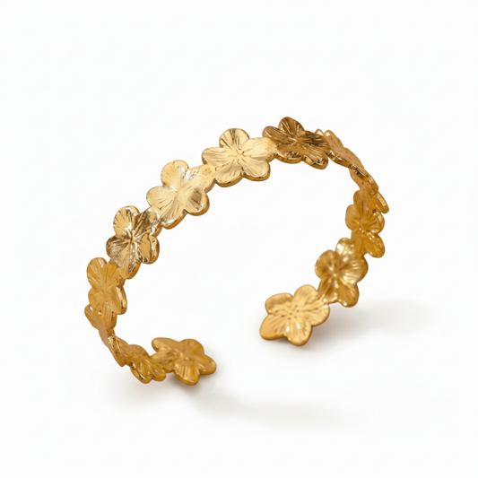 Guld blomarmband med vit bakgrund